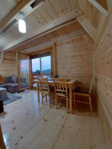a dining room with a wooden table and chairs at Holiday Homes B&V in Žabljak