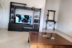 sala de estar con TV y mesa de madera en Thea family apartments 4, en Yénion