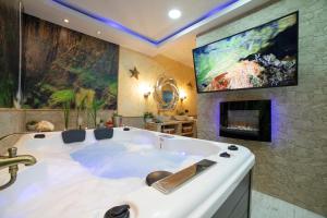 a large white tub in a room with a fireplace at APARTAMENTO ESTRELLA SAUNA SPa JACUZZI in Alhama de Aragón