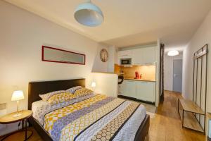 a bedroom with a bed and a kitchen at Le Brienne Toulouse Centre in Toulouse