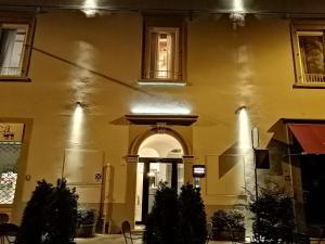 a large yellow building with an archway in front of it at Palazzo 42 - Boutique Hotel & Suites in Pistoia