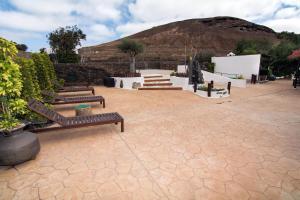 a patio with benches and a mountain in the background at BUGANVILLA MOLINO in Tinajo