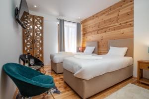 una habitación de hotel con 2 camas y una silla en Hotel NORTH STORY - Luxury Chalet - Apartments & rooms en Žabljak