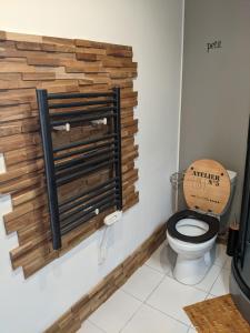 a bathroom with a toilet with a wooden wall at Appartement cosy à Nantes avec terrasse in Nantes