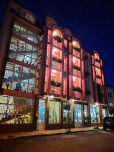 a large building with lit up windows at night at Art Villa Rozalia in Ravda