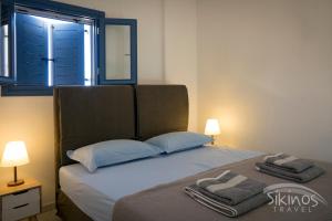 a bedroom with a bed with two towels on it at House Of Kastro in Sikinos