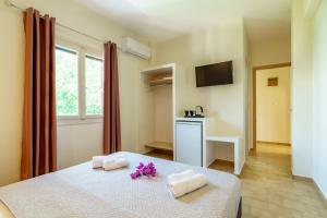 a bedroom with a bed with towels and flowers on it at Irini studios in Skiros
