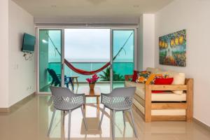 ein Wohnzimmer mit einem Tisch, Stühlen und einem Sofa in der Unterkunft Magico Apartamento Frente al Mar 3 Habitaciones AR51 in Coveñas