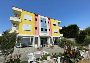 a colorful building with tables and chairs in front of it at MEGA Apartments in Fushë-Draç