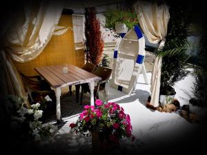 a patio with a wooden table and some flowers at Casa Fotografului in Constanţa