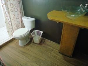 een badkamer met een wit toilet en een wastafel bij Don Jaime - Hostel in Puerto Maldonado