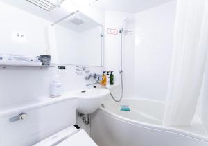 a white bathroom with a sink and a shower at APA Hotel Kanazawa-nishi in Kanazawa
