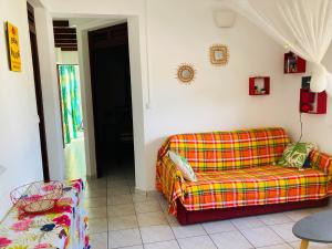 een woonkamer met een bank en een stoel bij Paradis Caraïbes in Sainte-Anne