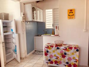 a small kitchen with a table and a refrigerator at Paradis Caraïbes in Sainte-Anne
