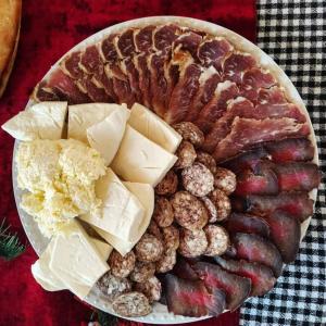 a plate of food with meats and cheese on a table at Katun Ljeljenak in Plužine