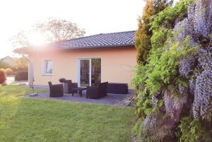 a house with a garden with purple flowers at Ferienhaus Am Anger in Gustow