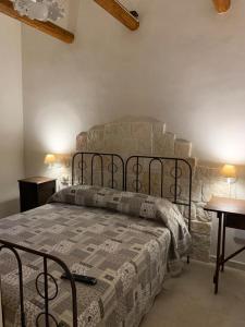 een slaapkamer met een bed en een stenen muur bij Casa Uliveto in Alberobello
