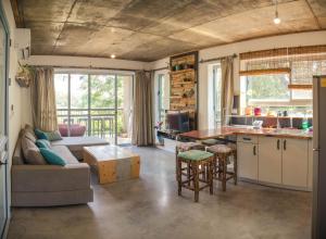 a kitchen and living room with a couch and a table at צימרים בצפון - עץ נוי in Sheʼar Yashuv