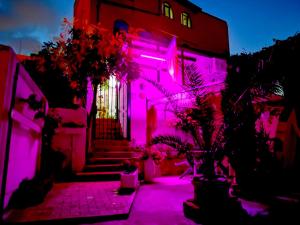 a building with pink lights on the side of it at Casa Fotografului Studio Marines in Constanţa
