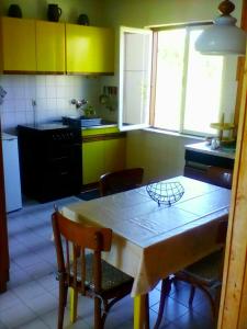 a kitchen with a table and chairs and yellow cabinets at Apartment Zan i Anamarija in Petrcane