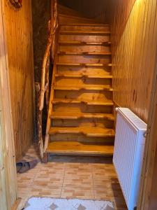 a wooden staircase in a room with a heater at VХаті in Slavske