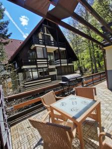 a patio with a table and chairs in front of a house at Apartament Kalinderu K2 Busteni in Buşteni