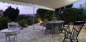 a table and chairs under an umbrella on a patio at Hannas Paradise - Villa Evi in Skafidia