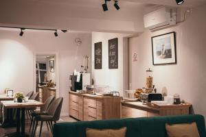 a living room with a green couch and a kitchen at Nest Guesthouse in Drobeta-Turnu Severin