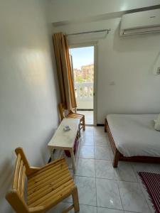 Zimmer mit einem Bett, einem Stuhl und einem Fenster in der Unterkunft Venus hotel luxor 日本人 大歓迎 in Luxor
