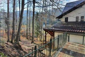 a house with a fence in the woods at Sorica Studio - near the ski slopes in Azuga