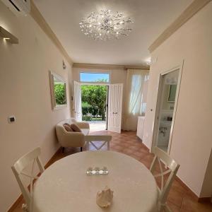 ein Wohnzimmer mit Tisch und Stühlen und einem Kronleuchter in der Unterkunft Il Lusso Del Silenzio in Ugento
