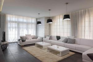 a living room with a white couch and a table at SG Villa in Sozopol