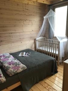 1 dormitorio con cuna y 1 cama en una habitación en Domek pod brzozami, en Krąg