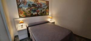 a bedroom with a bed and a painting on the wall at Hotel Maravillas del Mundo in Calpe