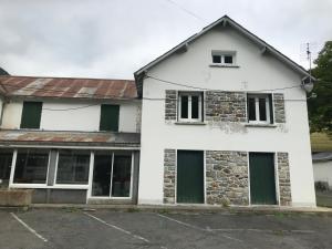 ein weißes Haus mit grünen Türen und Fenstern in der Unterkunft Résidence Gavarnie in Gèdre