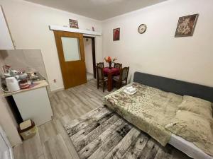 a bedroom with a bed and a dining room with a table at Apartmani Miro Trebinje in Trebinje