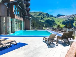 uma piscina com montanhas ao fundo em Charming 6th-floor 2-bedroom apartment with fireplace em Flaine