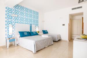 Un pat sau paturi într-o cameră la Hotel Magna Grecia