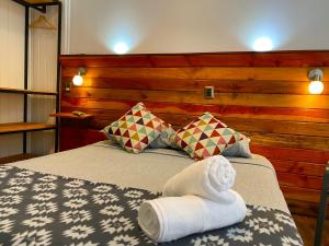 a bedroom with a bed with towels on it at VOY Hostales - Poniente in Viña del Mar