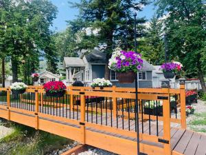 a wooden fence with potted flowers in front of a house at Brookside Motel in Golden