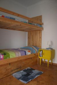 1 dormitorio con litera y mesa amarilla en Santa Beach House, en Santa Cruz