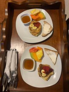two plates of food on a wooden table at Hotel Mansion Del Rey in Antigua Guatemala