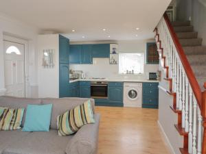 a living room with a couch and a kitchen at The Nest in Chathill