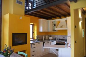 eine Küche mit gelben Wänden und weißen Schränken in der Unterkunft Tramonto Casa Barga Toscana ristrutturata 2021 in Barga