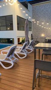 a deck with chairs and a table and a pool at Victoria Regia Hotel in Iquitos