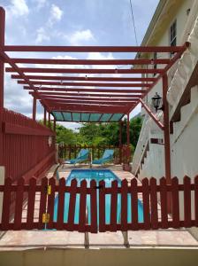ein Pool mit einem roten Holzzaun und einem Zaun am Ostufer in der Unterkunft Comfort Suites - Two Bedroom Apartment in Choiseul