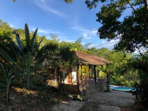 a small house with a swimming pool next to a tree at La Toscana Campestre in Viotá