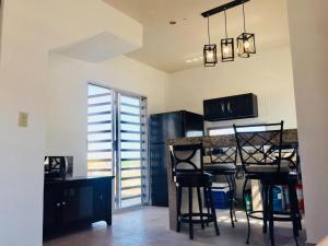 a kitchen with a table and chairs in a room at Tu casa con pérgola en La Paz BCS in La Paz