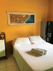 a bed in a room with a painting on the wall at Pousada Ilha De Boipeba in Ilha de Boipeba