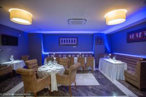 jadalnia ze stołami i krzesłami oraz niebieskimi ścianami w obiekcie Charleson Luxury Hotel w mieście Port Harcourt
